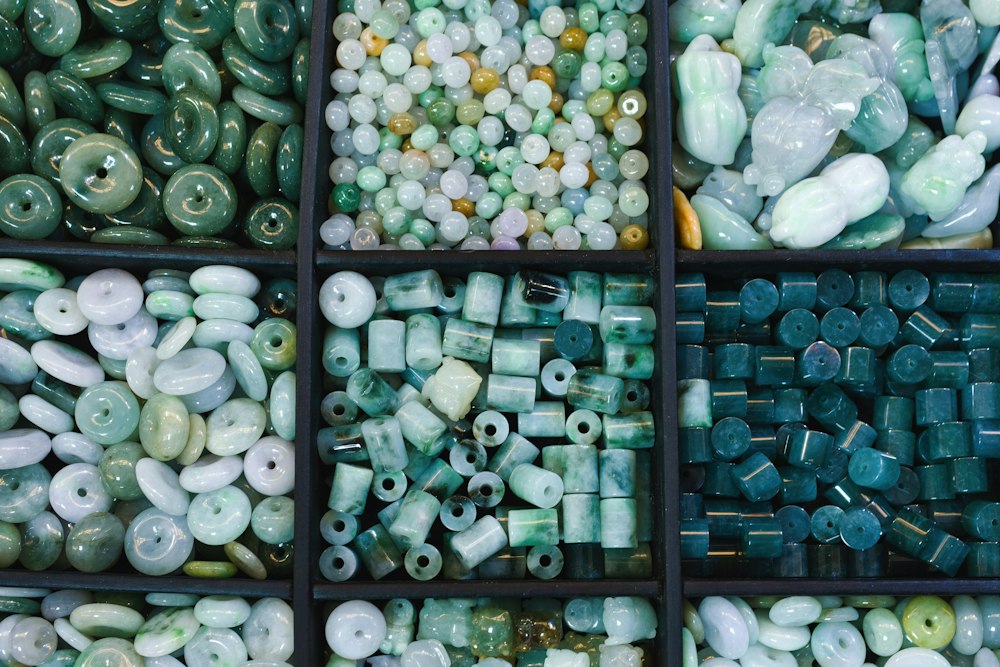 Green and white jade beads arranged in compartments