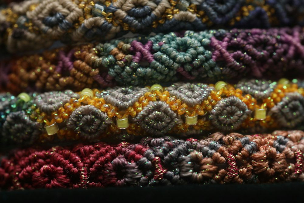 A stack of warm woven bracelets in earthy tones